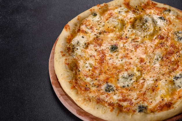 Savoureuse pizza au four avec tomates, fromage et champignons sur un fond de béton foncé. cuisine italienne