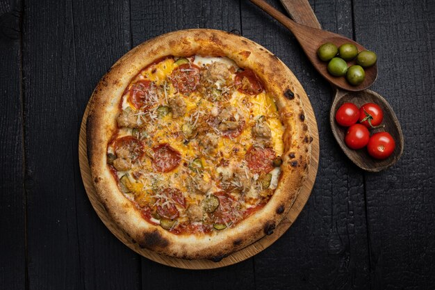 savoureuse pizza au fromage et légumes sur une table en bois sombre