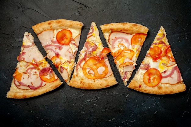 savoureuse pizza au jambon, tomate, piment, sauce tomate, fromage mozzarella sur fond de pierre