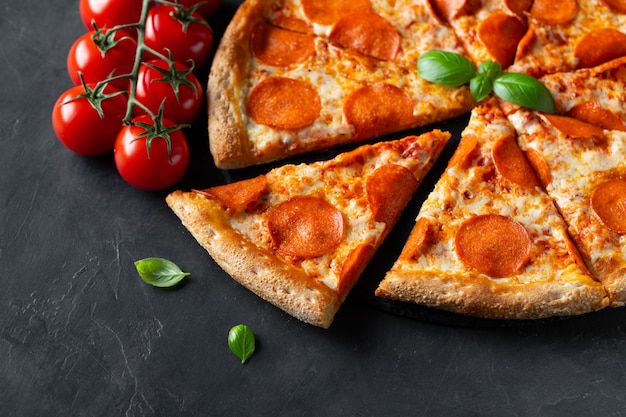 Savoureuse pizza au pepperoni sur béton noir