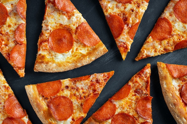 Savoureuse pizza au pepperoni sur fond de béton noir