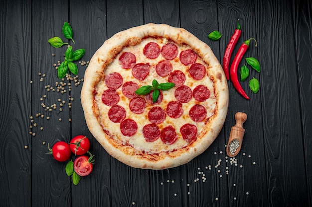 Savoureuse pizza au pepperoni et ingrédients de cuisine tomates basilic