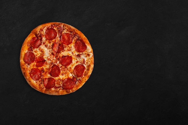 Savoureuse pizza au pepperoni sur une surface sombre avec espace de copie.