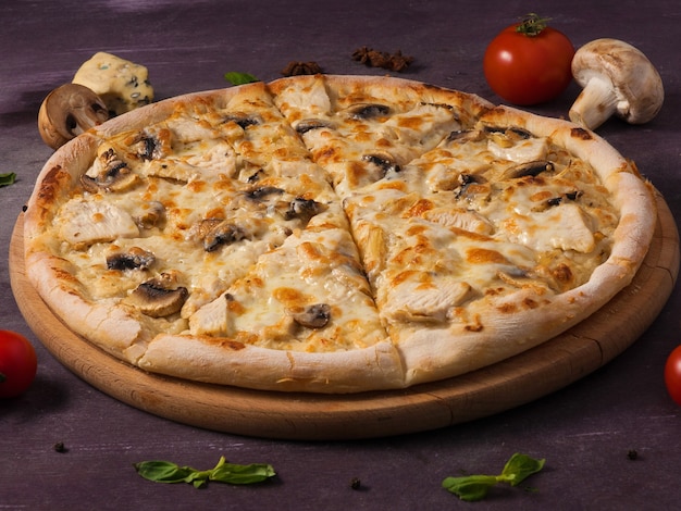 Savoureuse pizza au poulet et champignons sur une planche de bois