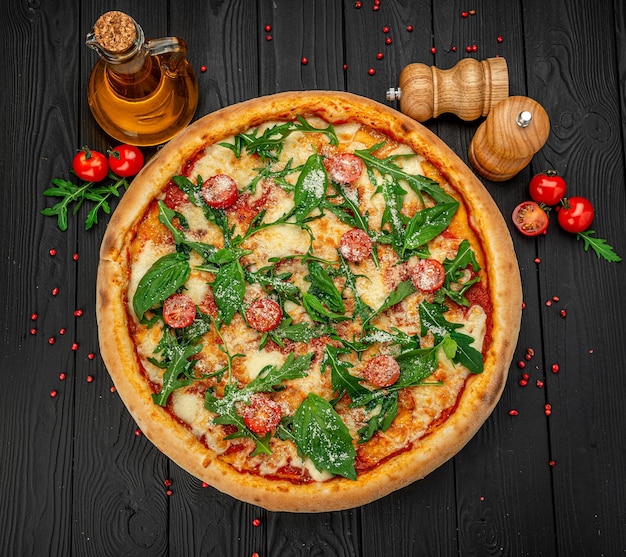 Savoureuse pizza italienne chaude sur une table en bois noire