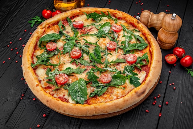 Savoureuse pizza italienne chaude sur une table en bois noire