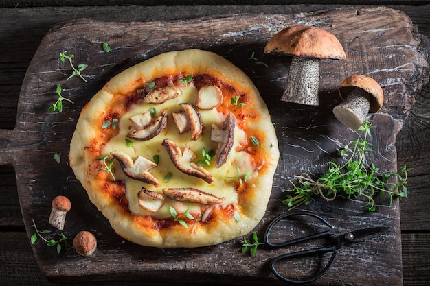 Savoureuse pizza rustique sur une vieille table en bois