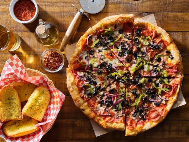 savoureuse pizza suprême avec des olives, des poivrons, des oignons et des saucisses