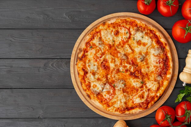 Savoureuse pizza sur la vue de dessus de la surface en bois noir