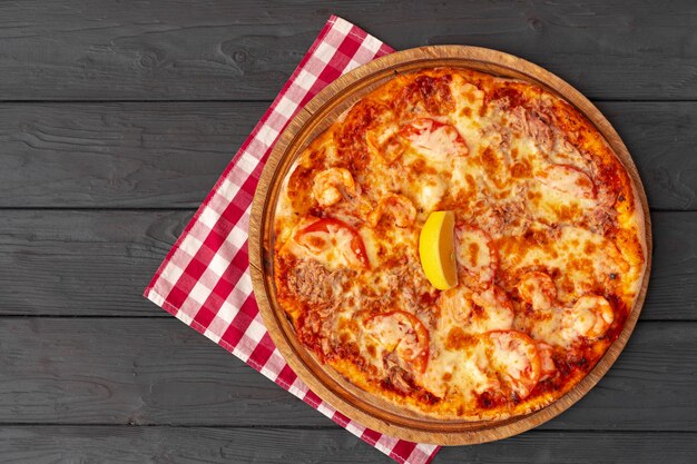 Savoureuse pizza sur la vue de dessus de la surface en bois noir