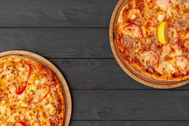 Savoureuse pizza sur la vue de dessus de la surface en bois noir