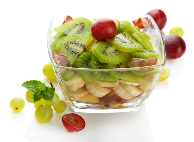 Savoureuse salade de fruits dans un bol en verre isolé sur blanc