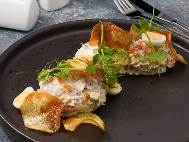 Savoureuse salade d'Olivier avec boeuf bouilli et chips de pommes de terre