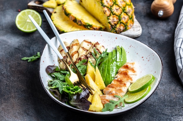 Savoureuse salade de poulet grillé, halloumi, avocat, salade de roquette verte, citron vert, sésame