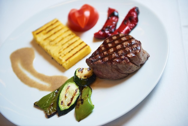 savoureuse viande de barbecue, steak de boeuf juteux avec fromage grillé et salade au restaurant