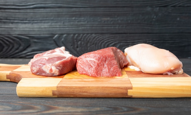 Savoureuse viande de veau crue ou de boeuf sur une planche à découper en bois