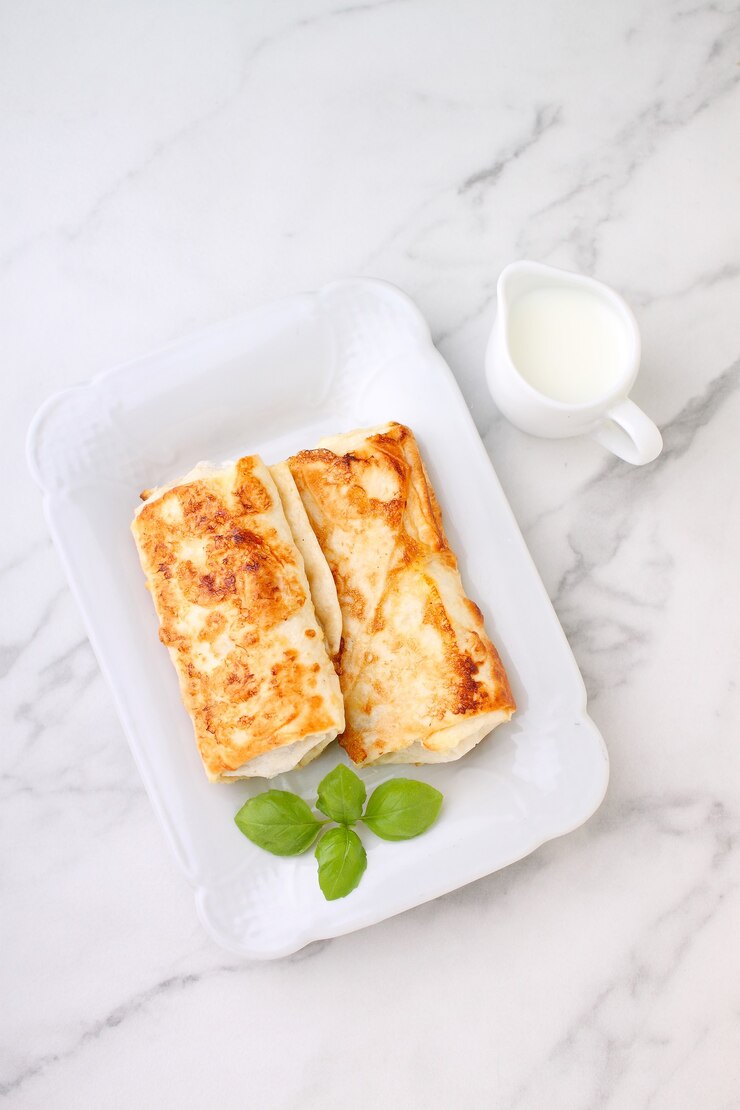 Savoureuses crêpes de crêpes farcies avec de la viande et de la sauce et du basilic. Photographie culinaire.