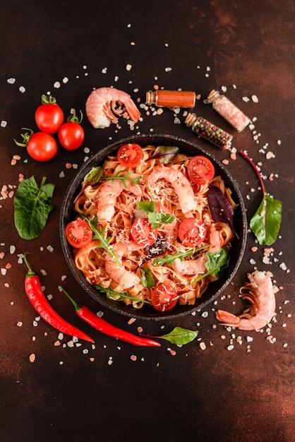 Savoureuses pâtes aux crevettes et à la tomate sur une poêle à frire