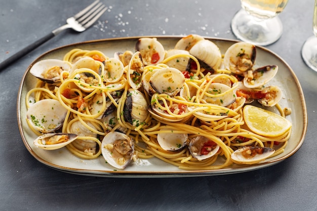 De savoureuses pâtes fraîches maison de palourdes alle vongole avec de l'ail et du vin blanc sur assiette. Fermer.