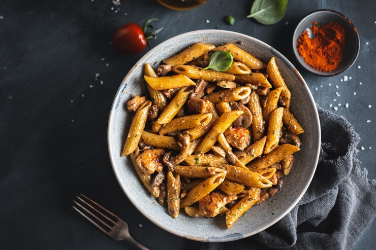 Savoureuses pâtes penne aux champignons en sauce. Servi sur assiette.