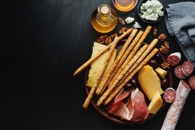 Savoureux apéritifs italiens classiques sur table sombre. Vue d'en-haut.