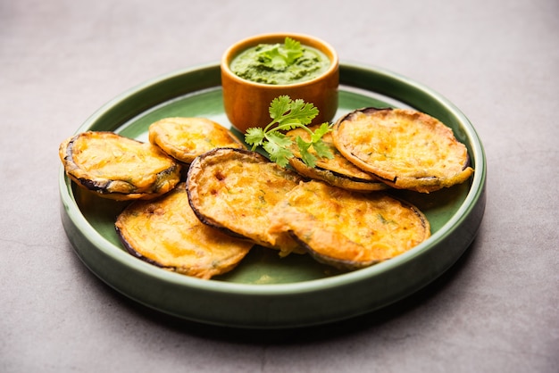 Savoureux Brinjal Pakora ou beignets d'aubergines croustillants, collation indienne à l'heure du thé servie avec chutney vert