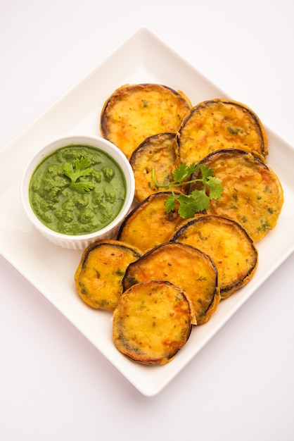 Savoureux Brinjal Pakora ou beignets d'aubergines croustillants, collation indienne à l'heure du thé servie avec chutney vert