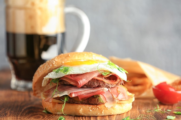 Savoureux burger au prosciutto et oeuf sur table en bois