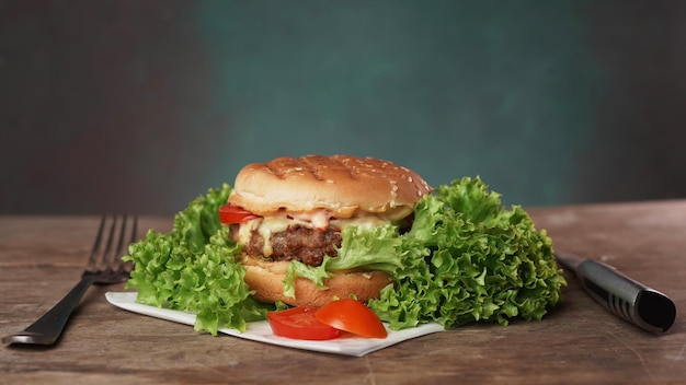 Un savoureux Burger se trouve sur une table en bois sur un fond vert