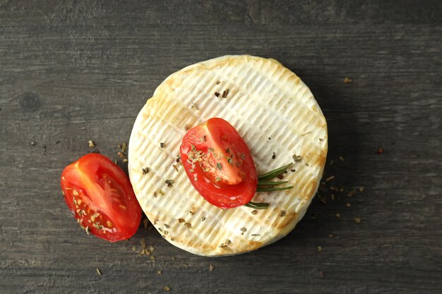 Savoureux camembert grillé sur fond de bois foncé.