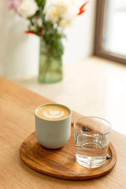 savoureux cappuccino chaud sur table en bois à côté de la fenêtre