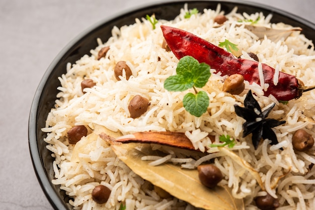 Savoureux Chana Pulao épicé ou Pulav ou pilaf cuit avec du riz basmati et des pois chiches pois chiches noirs ou blancs aux épices