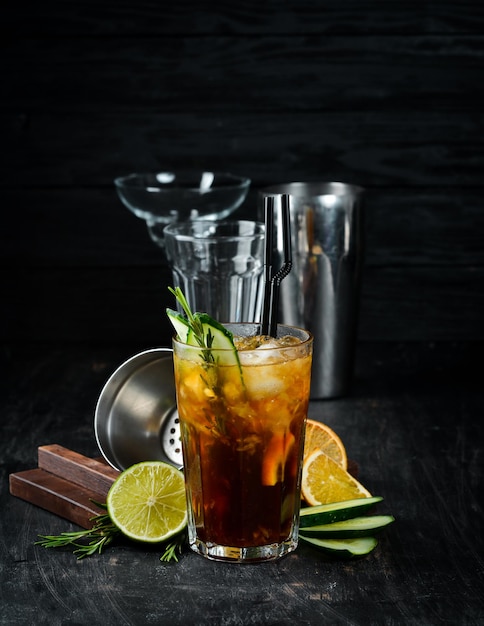 Savoureux cocktail alcoolisé Cola whisky concombre et glace Sur un fond en bois Vue de dessus