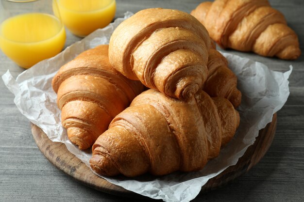 De savoureux croissants et jus sur table texturée grise