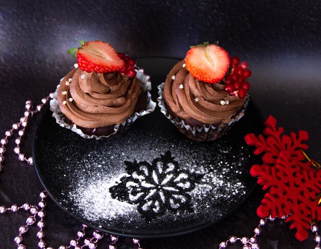 Savoureux cupcakes au chocolat avec fraises et sucre en poudre.