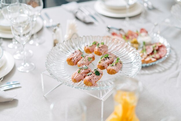 De savoureux éclairs sont disposés sur un plateau transparent recouvert de sucre rose belle table à dessert