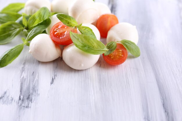 Savoureux fromage mozzarella au basilic et tomates sur table en bois