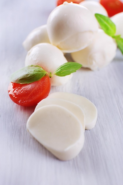 Savoureux fromage mozzarella au basilic et tomates sur table en bois