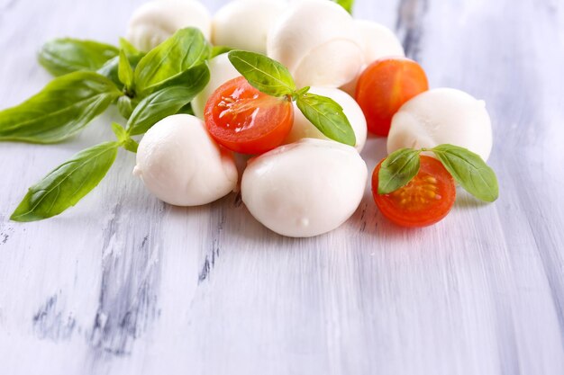 Savoureux fromage mozzarella au basilic et tomates sur table en bois