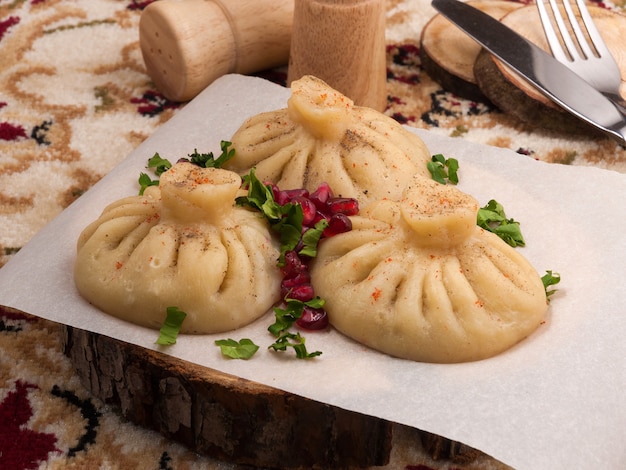 Savoureux khinkali au bœuf, garni de graines de grenade et d'herbes.