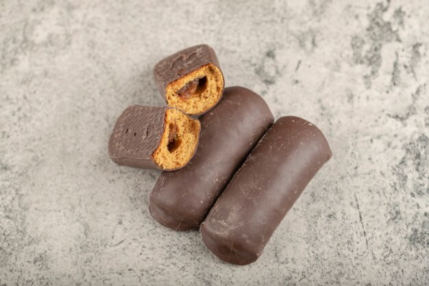 De savoureux mini gâteaux glacés au chocolat sur une surface en pierre.