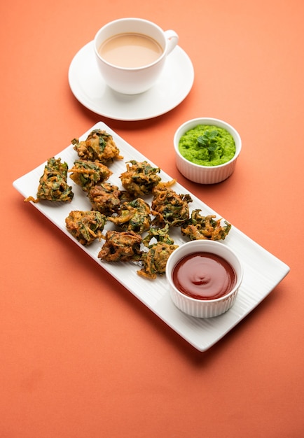 Savoureux Palak pakoda ou pakora fait maison, connu sous le nom de Firtters aux épinards, servi avec du ketchup. Collation préférée à l'heure du thé en Inde