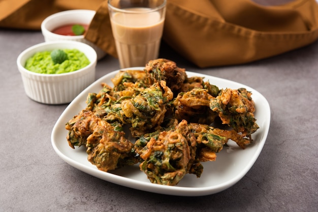 Savoureux Palak pakoda ou pakora fait maison, connu sous le nom de Firtters aux épinards, servi avec du ketchup. Collation préférée à l'heure du thé en Inde