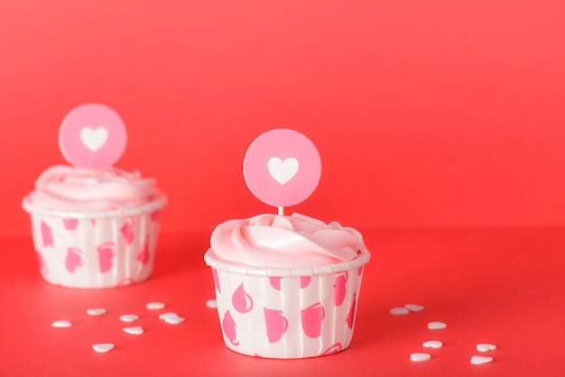 Savoureux petits gâteaux à la crème au beurre pastel rose sur fond rouge