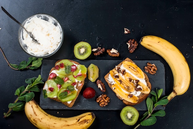 Savoureux sandwiches sucrés avec bananes, noix et chocolat, kiwi, fraises et menthe