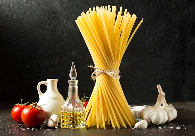 Savoureux spaghettis crus de cuisine italienne fraîche et colorée sur fond noir de table de cuisine