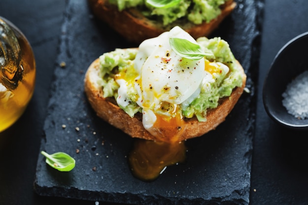 Savoureux Toasts Appétissants Avec Avocat Et œuf Servis Sur Une Planche Sombre.