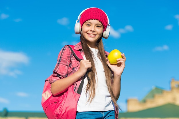 Savourez le goût de bien manger Un enfant heureux tient une pomme ensoleillée à l'extérieur Collation de fruits Habitudes alimentaires saines Nourriture végétarienne Régime alimentaire et régime Vitamine nutrition Bien manger Vacances d'été