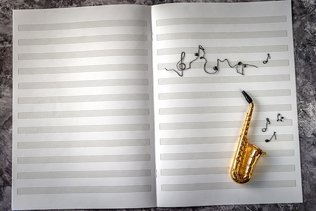 Photo saxophone doré sur fond de carnet de musique avec les notes