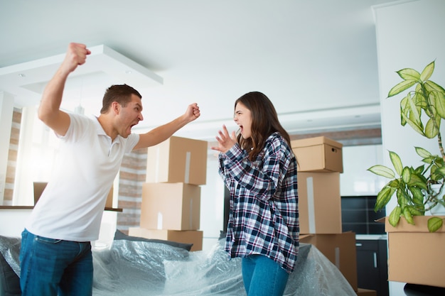 Scandale lors du déménagement dans une nouvelle maison. Jeune couple se quereller dans un nouvel appartement près de boîtes en carton et.